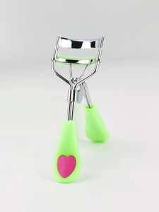 Detail of eyelash curler with green silicone pad and heart pattern handle