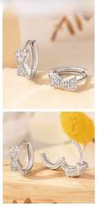 Macro detail of silver bow earrings with micro-set cubic zirconia and clasp mechanism