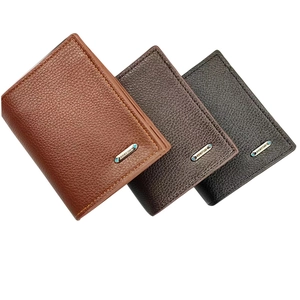 Detalle de tres carteras verticales de cuero en marrón y negro con logotipo de metal