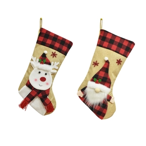 Detail of linen Christmas stockings with 3D elk and gnome patterns and plaid cuffs