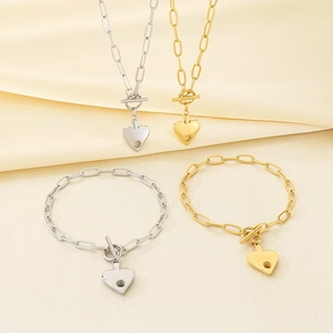 Detail of 18K gold and silver heart pendant necklaces with paperclip chain and OT clasp
