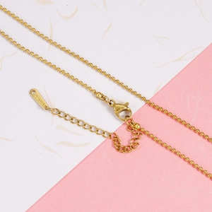 Detail of gold stainless steel ball chain featuring a lobster clasp and S.STEEL engraved tag
