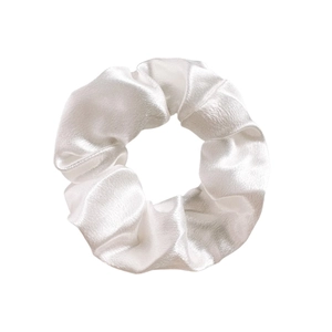 Macro shot of glossy white satin scrunchie showing detailed fabric texture and silky folds