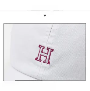 Gros plan sur une casquette en coton blanc avec broderie détaillée de la lettre H en 3D
