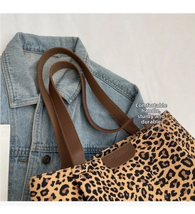 Détail du cabas imprimé léopard Boons avec poignées en cuir marron et logo surpiqué