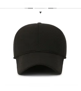 Detail of black winter baseball cap with textured fabric and small shield metal logo