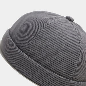 Gros plan du bonnet docker en velours côtelé gris foncé avec texture tricotée