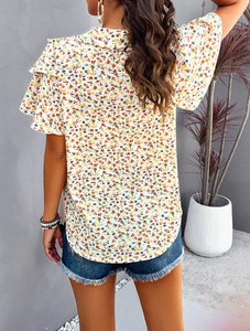 Rear view of floral short-sleeve top featuring elegant ruffle cuffs and a white base print