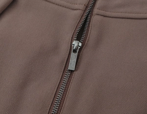 Détail macro de la fermeture éclair en métal et de la texture du tissu marron du pantalon