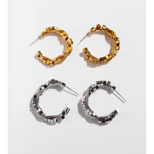 Modern C-shaped twisted metal hoop earrings in gold and silver finish with beaded texture