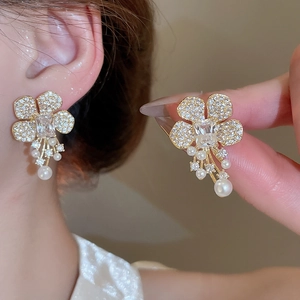 Close-up of zircon flower earrings with long tassels and elegant pearl accents