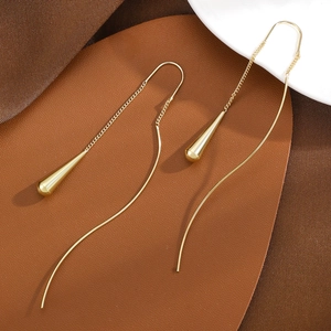 Elegant gold drop tassel earrings with long chain dangles on premium leather background