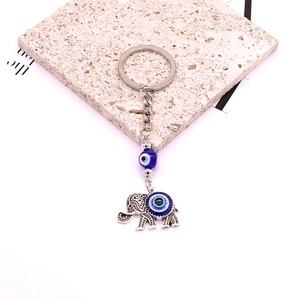Bohemian silver elephant keychain with blue evil eye bead on a natural stone base