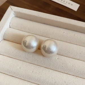 Détail macro de grandes boucles d'oreilles perles rondes dans un coffret à bijoux