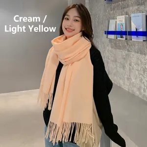 Detailed view of pale yellow pashmina scarf with soft fringe edges and warm texture