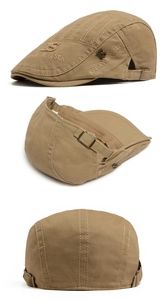 Detailed view of khaki cotton flat cap featuring metal logo plate and adjustable buckle
