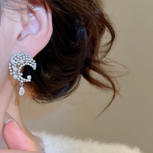 Detailed view of crescent moon stud earrings with pearls and a water drop pendant