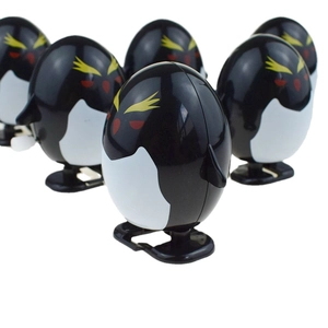 Groupe de jouets pingouins à remonter avec sourcils dorés et ventre blanc