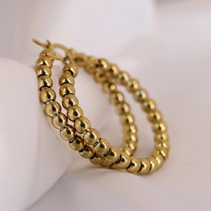 Macro shot of 14K gold-plated stainless steel 4mm bead hoop earrings on white silk fabric