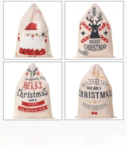 Detailed view of four festive canvas Christmas drawstring gift bags with Santa and reindeer prints
