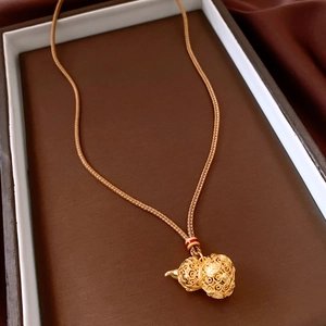 Macro detail of 24k gold-plated hollow gourd pendant with intricate filigree texture