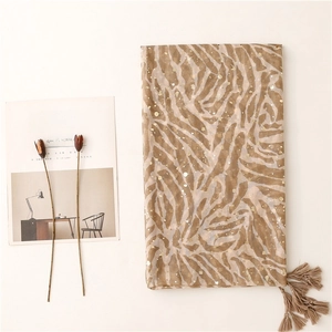 Detail showing gold zebra pattern on brown cotton linen scarf with tassel fringe