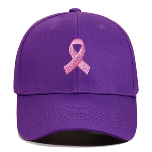 Close-up of purple baseball cap featuring a detailed pink ribbon embroidery on front