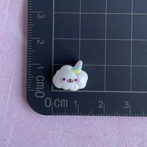 Close-up of a mini resin unicorn cloud accessory with a ruler showing the 1.5cm size
