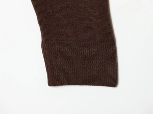 Detailed close-up of dark brown ribbed knit cuffs on a stylish women sweater