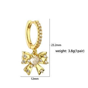 Detailed view of gold bow earrings with pink zircon dimensions 23.2mm by 12mm