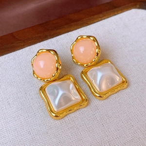 Detail of vintage square faux pearl and round candy-colored resin earrings in gold frames