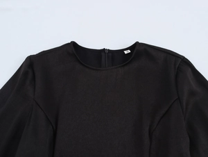 Détail du col rond avec fermeture éclair invisible et étiquette S sur la robe noire