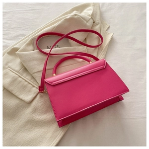 Détail macro du sac en cuir PU fuchsia avec coutures sur blazer blanc