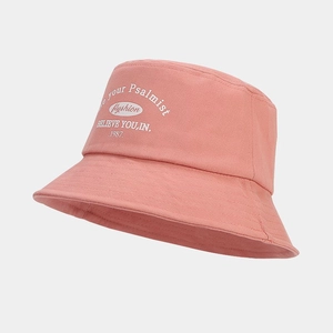 Detail showing white letter embroidery and fabric texture on pink cotton bucket hat