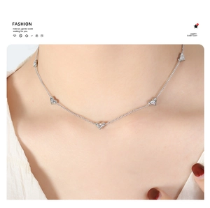 Detail of silver heart charm necklace featuring five small cubic zirconia pendants