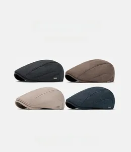 Detail showing knitted texture and metallic logo on british style newsboy caps in four colors