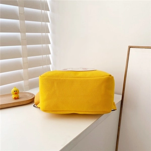 Detail of the rectangular reinforced canvas base and texture of the yellow toddler backpack