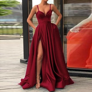 Detail of burgundy satin evening gown featuring a high slit and practical side pockets