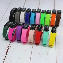 Flat lay of colorful digital watches with nylon straps on white wooden background
