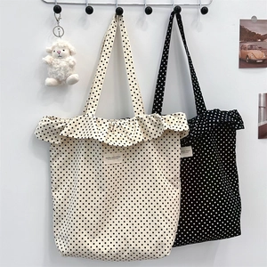 Polka dot canvas tote bags with ruffle trim hanging on hooks for daily commute use