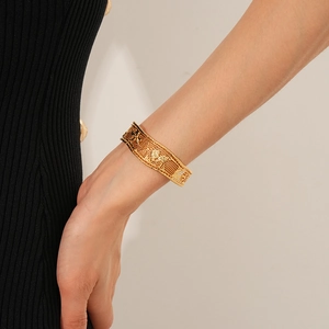 Close-up of 18k gold plated mesh cuff bracelet with intricate hollow lattice pattern