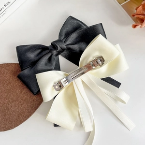 Elegant satin bow hair clips in black and cream white with metal spring fastener