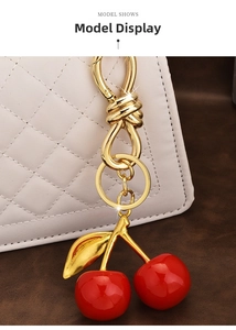 Macro shot of red cherry resin pendant with gold leaf on a white quilted bag