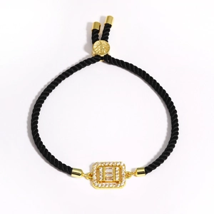 Detail of black woven rope bracelet with gold square pendant and micro-pave cubic zirconia