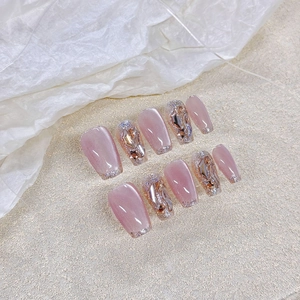 Faux ongles faits main œil de chat rose avec pointes French pailletées et strass brillants
