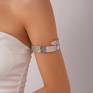 Detailed view of silver arm cuff with vintage embossed scroll patterns on upper arm