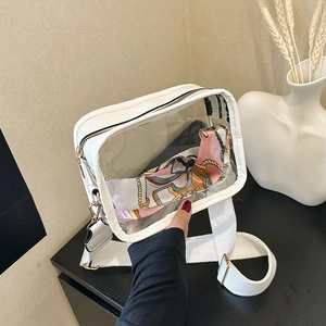 Detailed view of clear PVC square bag with white leather trim and stylish wide strap