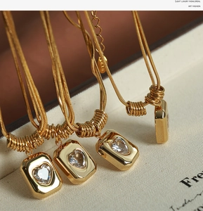 Detail of 18K gold snake chain with heart-shaped crystal in a rectangular pendant