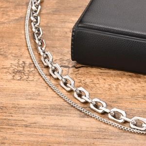 Close-up of double layer stainless steel chain bracelets on a rustic wooden texture