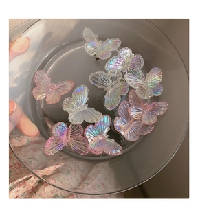 Vue macro de barrettes papillon irisées dans un plat en verre au fini nacré et brillant